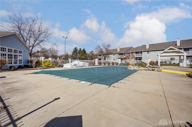 view of swimming pool with a patio, fence, a fenced in pool, and a residential view