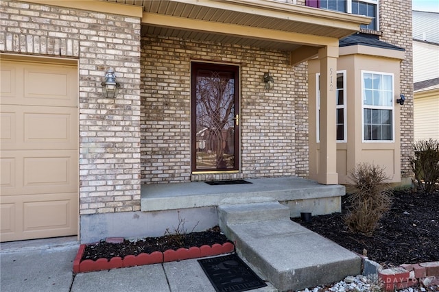 doorway to property with a porch, an attached garage, and brick siding