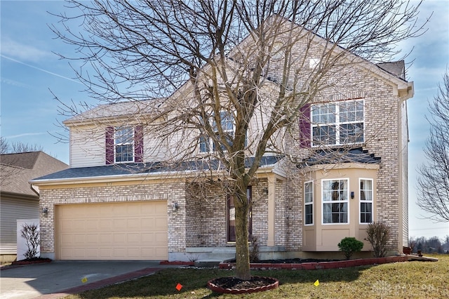 traditional home with brick siding, a front lawn, concrete driveway, and a garage