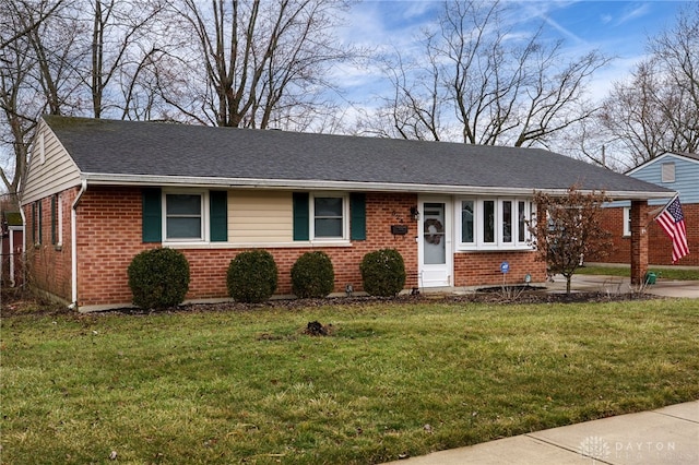 ranch-style house featuring brick siding, roof with shingles, and a front yard