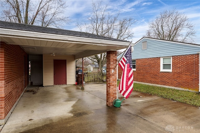 view of vehicle parking featuring an attached carport and fence