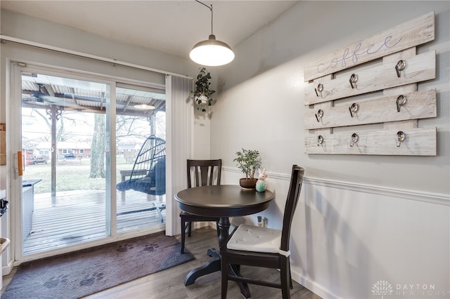 dining room featuring a wainscoted wall and wood finished floors