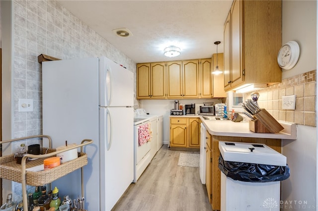 kitchen featuring light wood-style flooring, washer / clothes dryer, freestanding refrigerator, light countertops, and backsplash