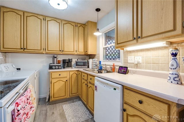 kitchen with stainless steel microwave, backsplash, dishwasher, independent washer and dryer, and a sink