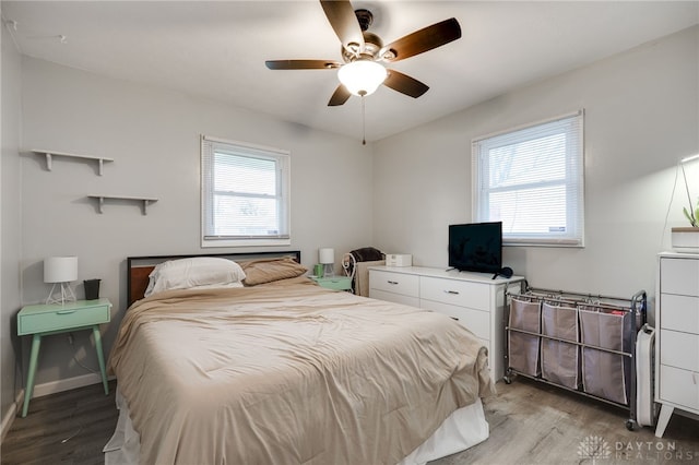 bedroom with baseboards, multiple windows, ceiling fan, and light wood finished floors