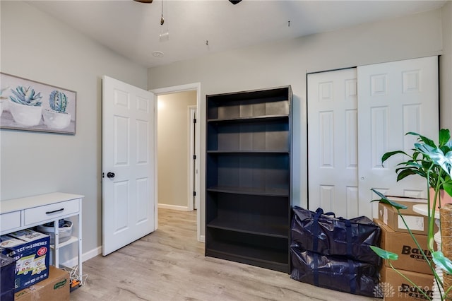 bedroom with a closet, baseboards, wood finished floors, and a ceiling fan