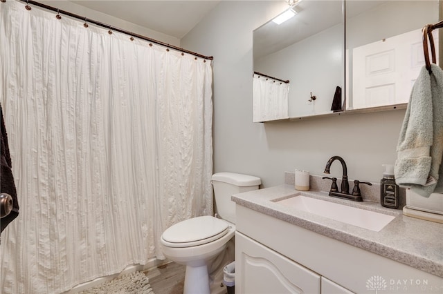 bathroom with vanity, a shower with curtain, toilet, and wood finished floors