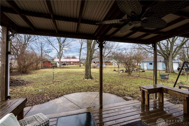 deck with a residential view, a lawn, a ceiling fan, and fence