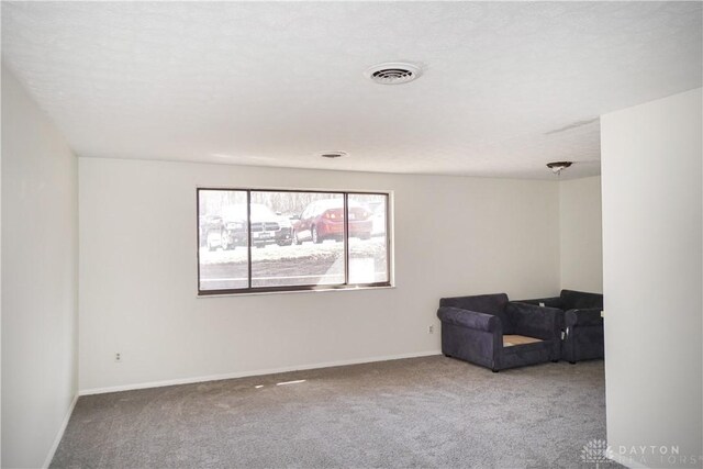 unfurnished room with visible vents, baseboards, and carpet