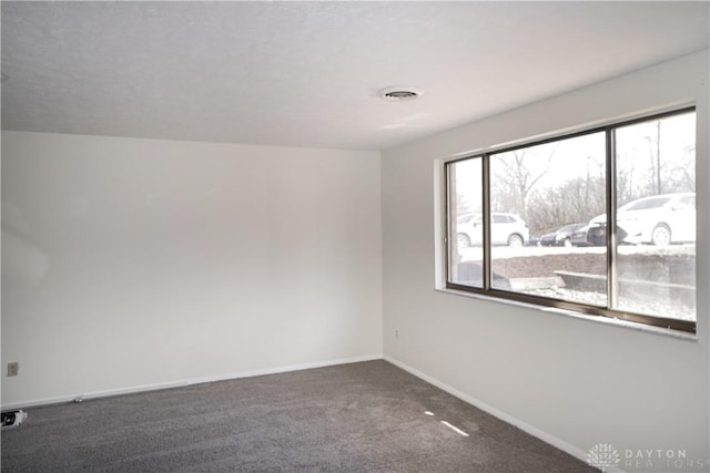 unfurnished room featuring visible vents, baseboards, and carpet floors