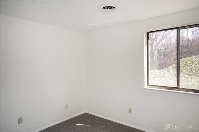 unfurnished room with visible vents, baseboards, and carpet flooring