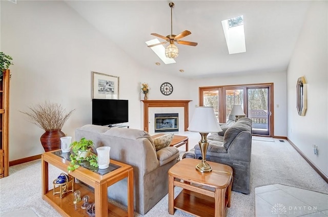 living room with visible vents, baseboards, light carpet, a skylight, and a ceiling fan