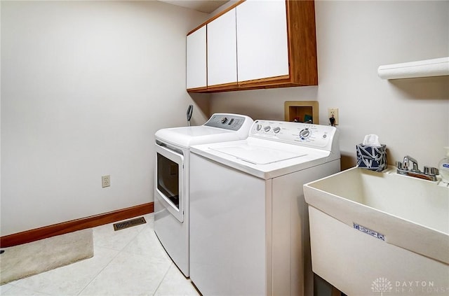 laundry room with visible vents, light tile patterned floors, cabinet space, independent washer and dryer, and a sink