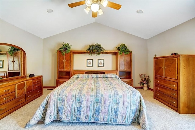 bedroom with a ceiling fan, vaulted ceiling, light colored carpet, and baseboards