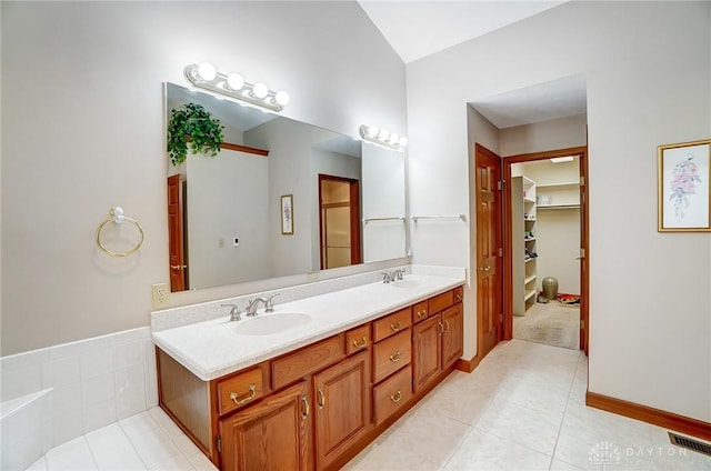 full bathroom featuring a sink, visible vents, a walk in closet, and double vanity