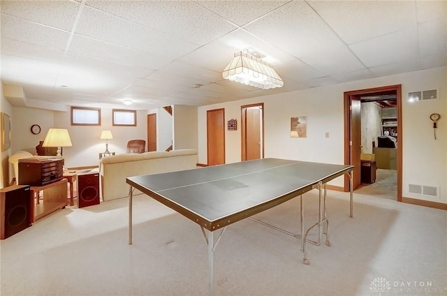 rec room featuring a paneled ceiling, visible vents, and light carpet