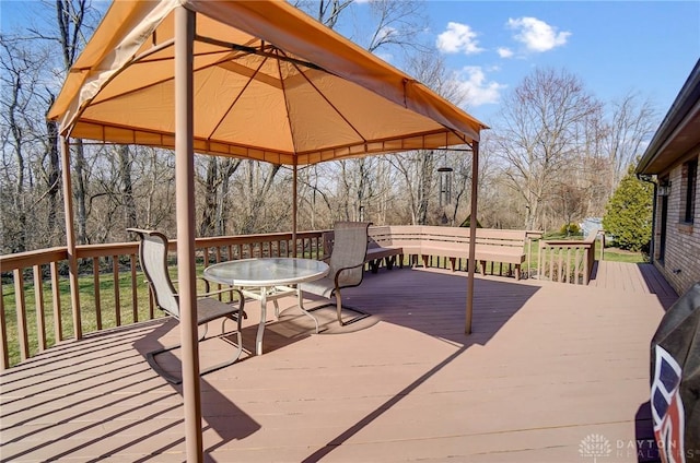 wooden deck with a gazebo and outdoor dining area