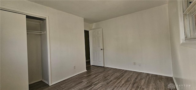 unfurnished bedroom featuring wood finished floors, a closet, and baseboards