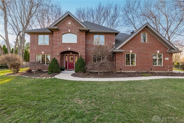 view of front of home featuring brick siding and a front yard