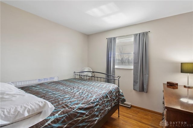 bedroom with baseboards and wood finished floors