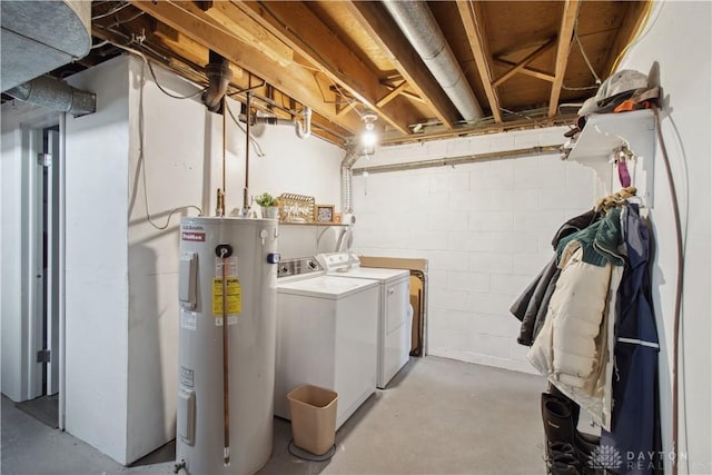 clothes washing area with washer and dryer, electric water heater, and laundry area