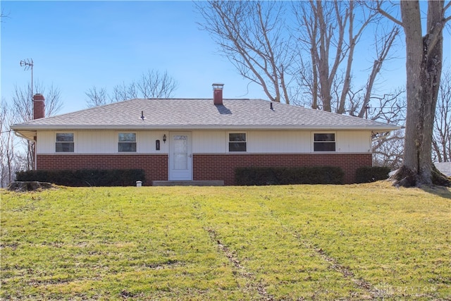 ranch-style home featuring brick siding, a chimney, and a front lawn