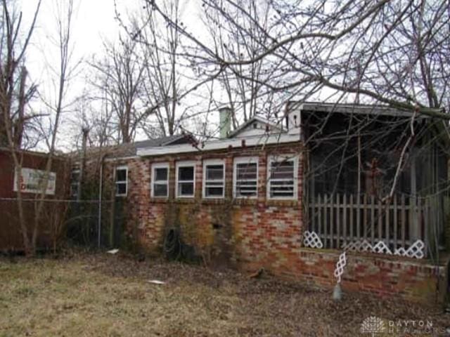 view of home's exterior with a chimney and fence