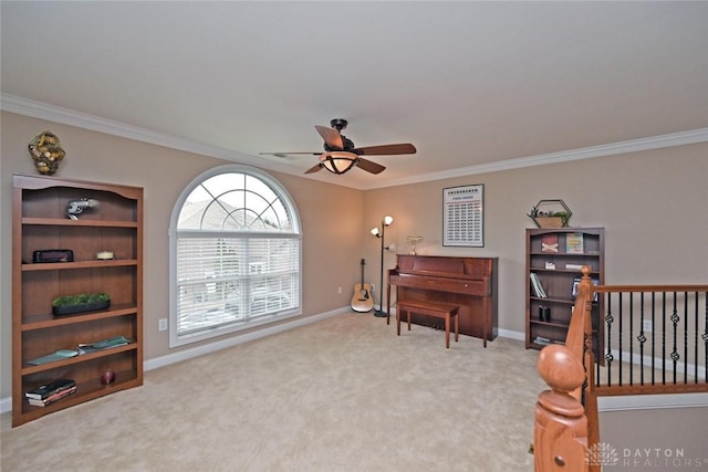 sitting room with carpet floors, ceiling fan, and crown molding