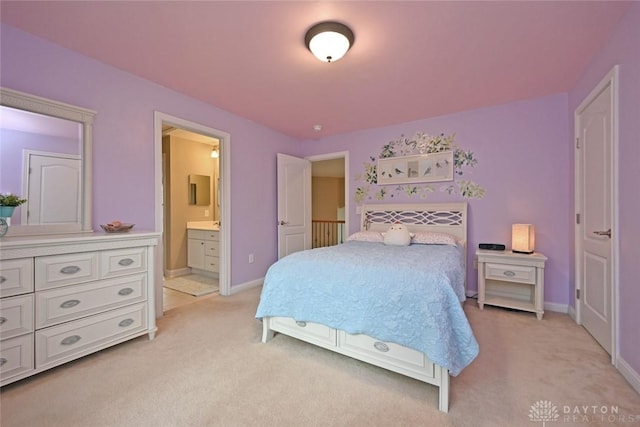 bedroom featuring light carpet, ensuite bath, and baseboards