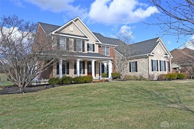 view of front of property featuring stone siding, covered porch, and a front yard