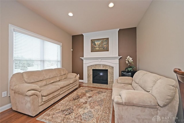 living area featuring recessed lighting, baseboards, wood finished floors, and a fireplace