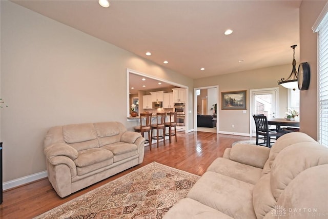 living room featuring recessed lighting, wood finished floors, and baseboards