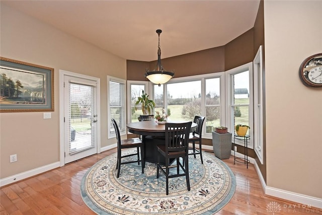 dining space featuring light wood-style flooring, a healthy amount of sunlight, and baseboards