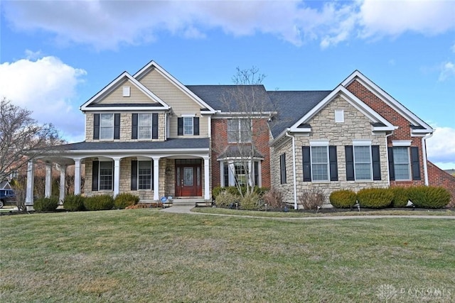 view of front facade featuring a front lawn, a porch, and stone siding