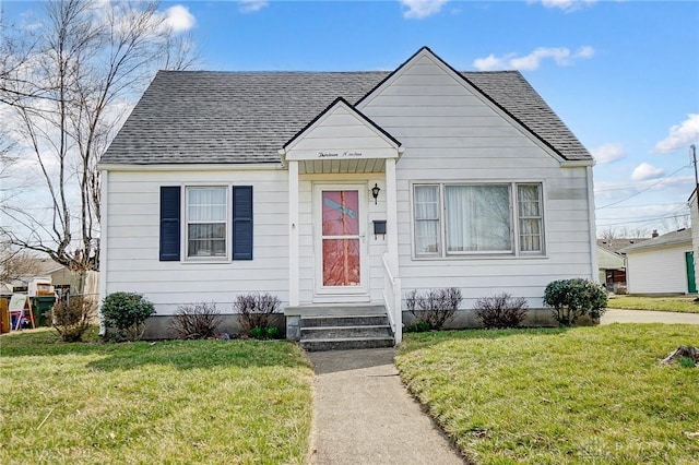 bungalow featuring a front yard and roof with shingles