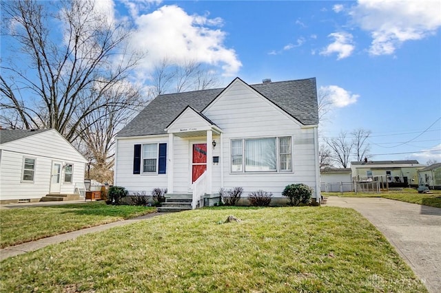 bungalow featuring a shingled roof, a front yard, and entry steps