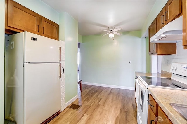 kitchen with white appliances, a ceiling fan, visible vents, under cabinet range hood, and brown cabinets