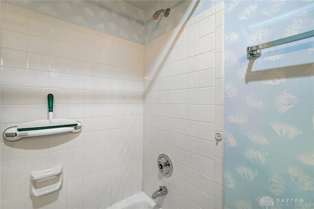 full bath featuring wallpapered walls and washtub / shower combination