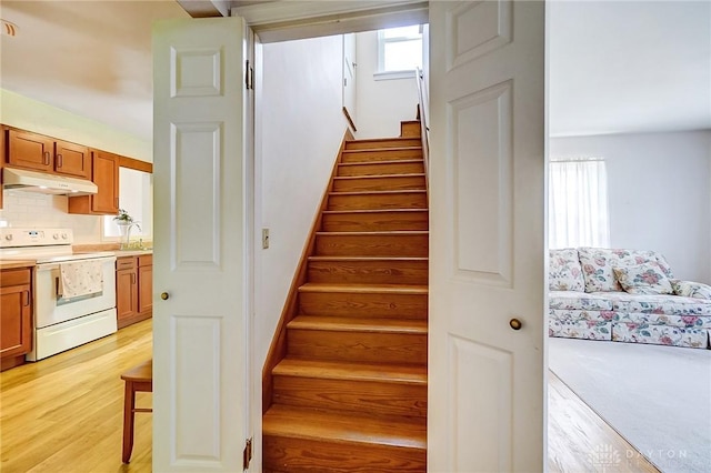 stairs featuring wood finished floors