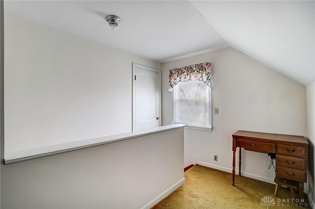 unfurnished office featuring baseboards, lofted ceiling, and carpet