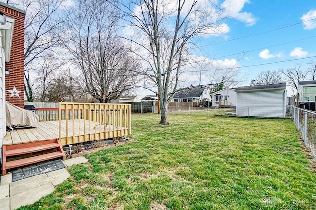 view of yard with an outbuilding, a wooden deck, and a fenced backyard