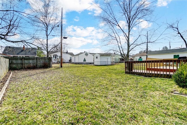 view of yard with a deck, a residential view, and a fenced backyard