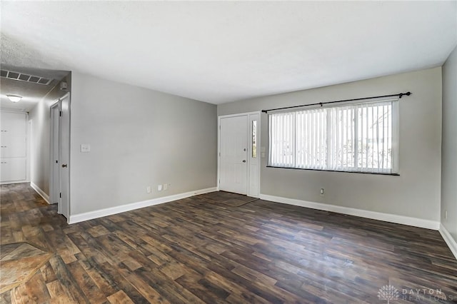 unfurnished room with visible vents, baseboards, and wood finished floors