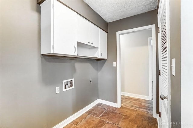 laundry room with hookup for a washing machine, baseboards, cabinet space, electric dryer hookup, and a textured ceiling