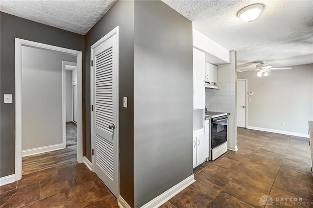 kitchen featuring under cabinet range hood, white cabinetry, electric stove, and a ceiling fan