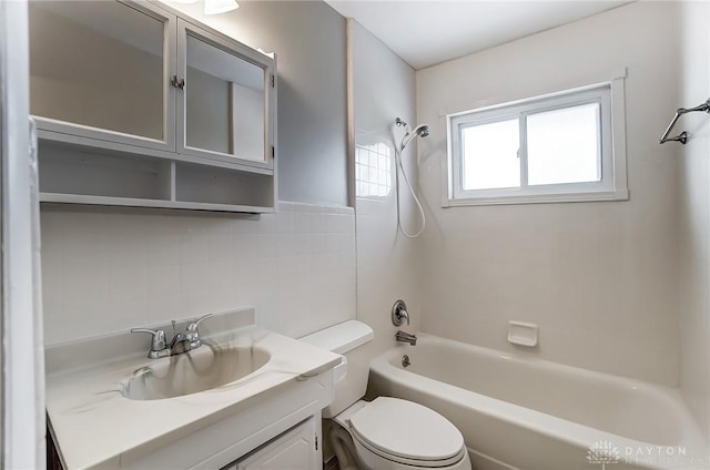 bathroom featuring tile walls, vanity, toilet, and shower / bathing tub combination