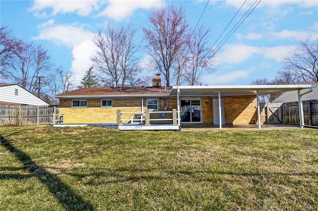 rear view of house with a yard, fence, and a chimney