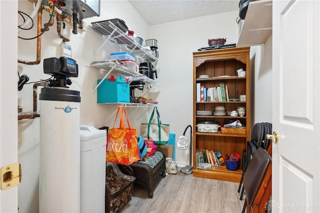 interior space featuring laundry area, wood finished floors, and a textured ceiling