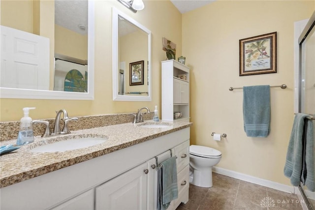 full bathroom featuring double vanity, tile patterned floors, toilet, and a sink