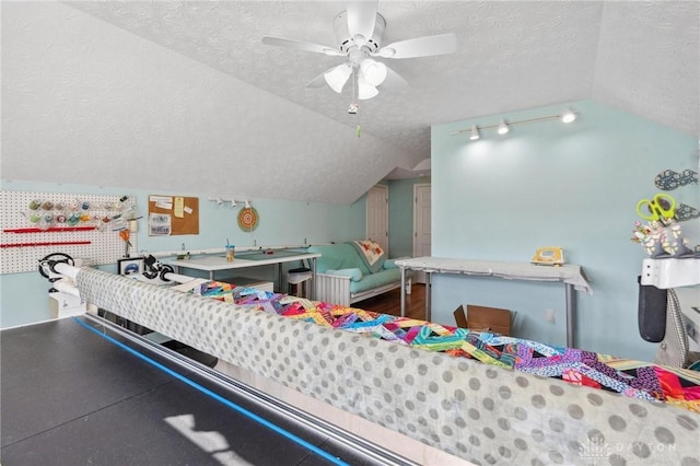 recreation room featuring a textured ceiling, wood finished floors, a ceiling fan, and vaulted ceiling